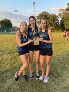 Three RB Cross Country competitors holding a plaque at the Elmwood Park XC meet
